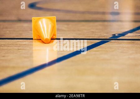 Campo di allenamento Orange Sports giacente su una superficie lucida del pavimento sportivo in legno. Calcio al coperto, campo di allenamento di pallacanestro Foto Stock