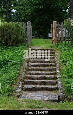 Scalinata che conduce al cortile del villaggio con scalini in pietra. Foto Stock