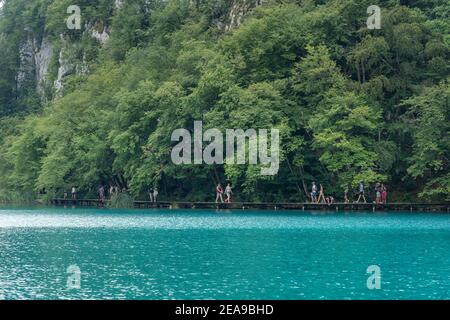 Plitvice, Croazia - 11 agosto 2020: Turisti a piedi da lago color acqua Foto Stock