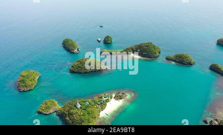 Bellissime isole tropicali con lagune blu nell'acqua azzurra del mare, vista aerea. Parco Nazionale Delle Cento Isole, Pangasinan, Filippine. Concetto di vacanza estiva e di viaggio Foto Stock