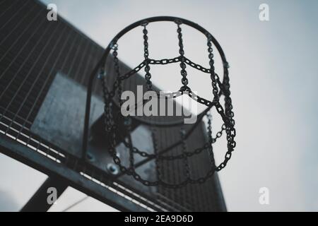 Tiro ad angolo basso di un vecchio cerchio da basket con un rete metallica Foto Stock