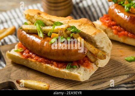 Panino di salsiccia di merguez frites fatto in casa con Harrisa su un bun Foto Stock