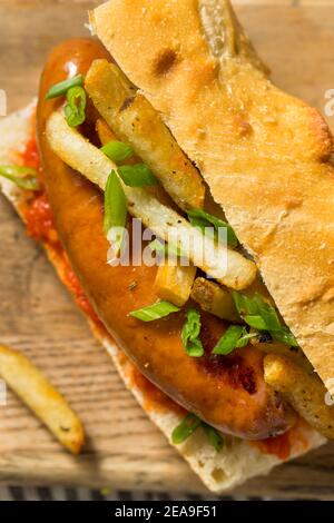 Panino di salsiccia di merguez frites fatto in casa con Harrisa su un bun Foto Stock