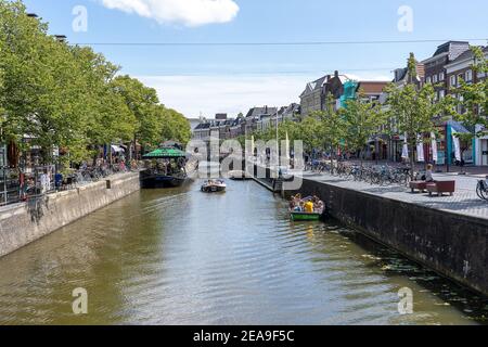 SNEEK, PAESI BASSI - 02 agosto 2020: Persone a bordo delle barche sui canali olandesi di Sneek godendo del sole Foto Stock