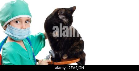 Ragazza in tuta chirurgica medica verde e maschera medica protettiva Gioca veterinario con gatto nero domestico isolato su bianco Foto Stock