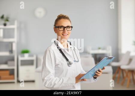 Ritratto di dottore, terapeuta, medico generico, in ospedale con appunti. Foto Stock