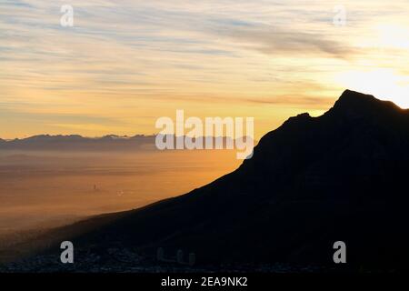 Vista dai Lions Head a città del capo, Africa, primo mattone, sole che splende dietro le montagne della città Foto Stock