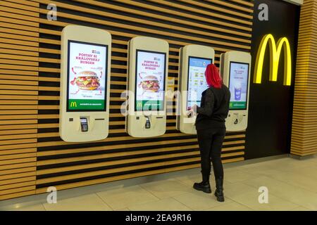 Una giovane donna sceglie un menu presso un chiosco self-service McDonalds self-service Repubblica Ceca Foto Stock