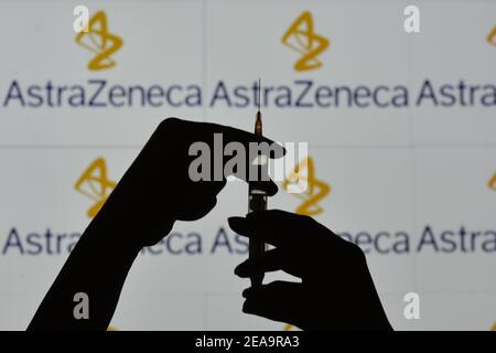 Irlanda. 7 Feb 2021. In questa figura è illustrata una silhouette di mani che tengono una siringa medica davanti al logo AstraZeneca visualizzato su uno schermo. Credit: Cezary Kowalski/SOPA Images/ZUMA Wire/Alamy Live News Foto Stock