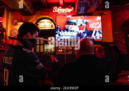 Philadelphia, Stati Uniti. 7 Feb 2021. I commensali parlano guardando Super Bowl LV alla Old Ale House di McGillin a Philadelphia, Stati Uniti. Credit: Chase Sutton/Alamy Live News Foto Stock