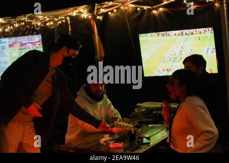 Philadelphia, Stati Uniti. 7 Feb 2021. Un operaio mascherato pulisce un tavolo da pranzo all'aperto durante il Super Bowl LV al Tradeesman's, un bar e ristorante, a Philadelphia, USA. Credit: Chase Sutton/Alamy Live News Foto Stock