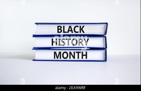 Simbolo del mese della storia nera. Libri con parole 'mese della storia nera'. Bel tavolo bianco, sfondo bianco. Storia nera concetto mese. Spazio di copia. Foto Stock
