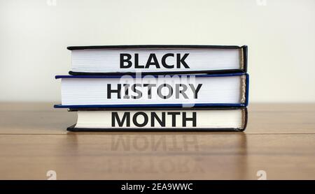 Simbolo del mese della storia nera. Libri con parole 'mese della storia nera'. Bel tavolo in legno, sfondo bianco. Storia nera concetto mese. Spazio di copia. Foto Stock