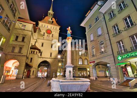 Berna, Svizzera - 23 agosto 2020: Scena urbana notturna della torre Kafigturm, una torre di guardia medievale e la fontana Anna Seiler in via Marktgasse. UNESCO Foto Stock