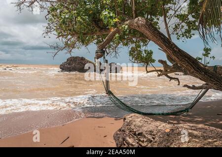 Un'amaca abbandonata su una spiaggia vuota in Axim Ghana Africa occidentale. Foto Stock