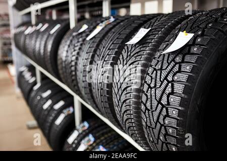 pneumatici per auto nuovi e usati sul rack del negozio. primo piano foto di pneumatici nel servizio automobilistico Foto Stock