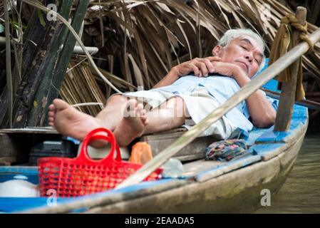 Vietnamita mentre si riposa sulla barca, Delta del Mekong, Vietnam Foto Stock