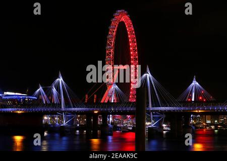 Ruota panoramica illuminata con ponte sul tamigi in foto notturna a lunga esposizione, Londra, Inghilterra, Regno Unito Foto Stock