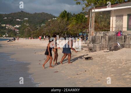 famiglia grenadiana a piedi cucciolo lungo la grande anse spiaggia grenada vento isole indie occidentali Foto Stock