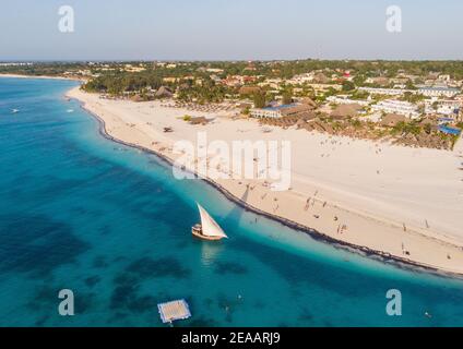 Vista aerea di barche a vela in legno vicino a Wide White Coastal Beach Line nel villaggio di Kendwa, Zanzibar Foto Stock