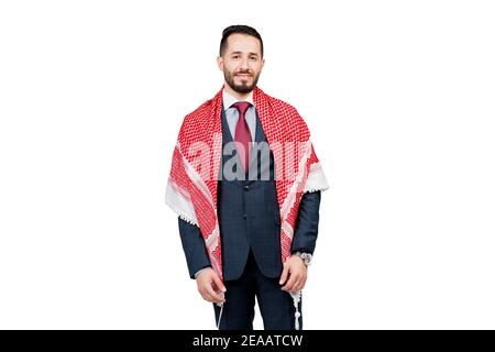 Bell'uomo d'affari arabo in tuta e shemagh sorride su sfondo bianco in studio. Ritratto di affari dell'uomo riuscito Foto Stock