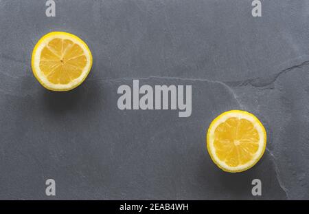 Limoni a fette su sfondo grigio ardesia Foto Stock