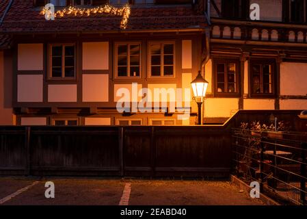 Germania, Sassonia-Anhalt, Wernigerode, illuminazione di strade storiche in un vicolo con case a graticcio Foto Stock