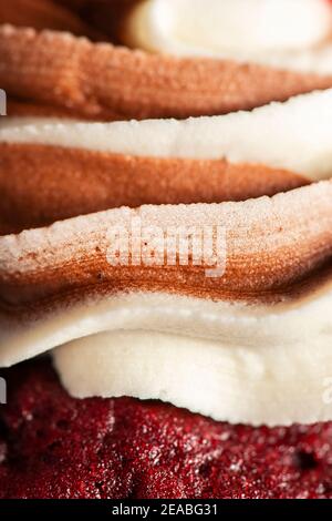 Cupcake di velluto rosso a tema San Valentino con cioccolato e vaniglia glassa di buttercream Foto Stock