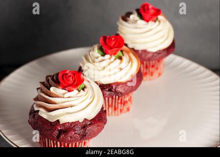 Cupcake di velluto rosso a tema San Valentino con cioccolato e vaniglia glassa di buttercream Foto Stock