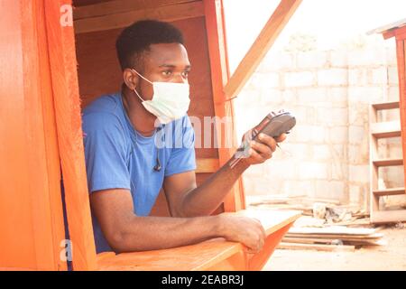 un giovane uomo d'affari africano che usa una macchina pos Foto Stock