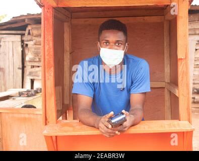 un giovane uomo d'affari africano che usa una macchina pos Foto Stock