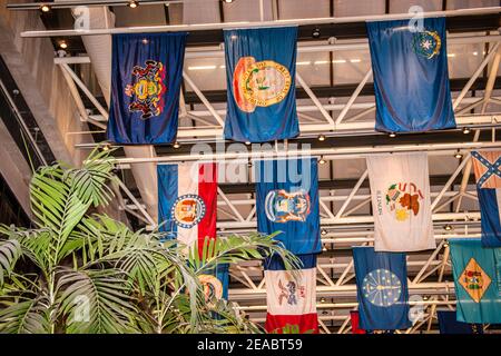 Le bandiere di stato sono appese sopra la lobby della stazione Metrorail del Government Center nel centro di Miami, Florida. Foto Stock