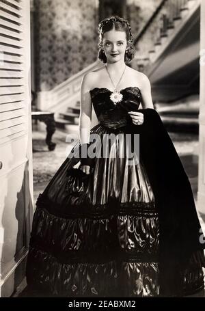 1936 , USA : l'attrice del cinema BETTE DAVIS ( 1908 - 1989 ) in JEZEBEL ( Jezebel figuria del vento ) Di William Wyler - CINEMA - FILM - attrice - ritratto - ritratto - collana - collana oro - orecchiino - orecchiine - orecchino - orecchini - boccoli - ricci - balli - spalline - spalle - borsetta - borsa - scollatura - decolleté - apertura collo - collana - gioiello - gioielli - gioielleria - bijioux - gioiello - gioielli - guanto - guanti - guanti - raso - raso - pizzo - anello ---- Archivio GBB Foto Stock