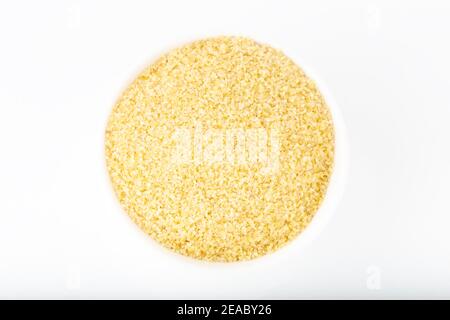Bulgur asciutto in ciotola bianca isolato su sfondo bianco. Foto Stock