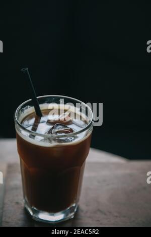 Caffè ghiacciato in un bicchiere alto su legno al caffè negozio Foto Stock