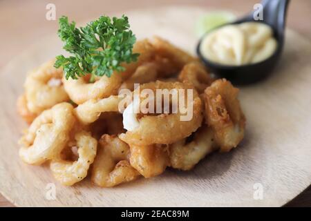 Caramari , Ang di calamari fritti croccanti con salsa tartaro su fondo di legno tradizionale cucina italiana Foto Stock