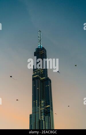 Top of Landmark 81 Tower a ho Chi Minh City al tramonto, con 6 aquiloni che volano vicino alla cima. Foto Stock