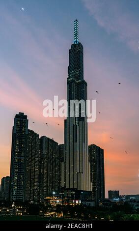 Landmark 81 Torre nella città di ho Chi Minh al tramonto, con molti aquiloni che volano nella zona delle case di Vin, Vietnam. Foto Stock