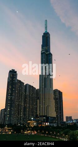 Landmark 81 Torre nella città di ho Chi Minh al tramonto, con aquiloni che volano nella zona delle case di Vin, Vietnam. Foto Stock