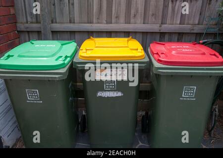 Contenitori per la raccolta dei rifiuti domestici codificati a colori, rispettivamente per rifiuti verdi (organici), riciclabili e discariche, Melbourne, Australia Foto Stock