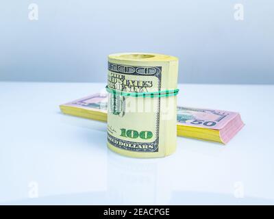 Un pacchetto di dollari americani in denaro rotolato in un rotolo. Denaro legato con una fascia elastica. Rotolo di dollari americani. Affari e finanza. Valuta e f Foto Stock