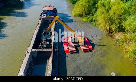 Sopra la vista sul drago scavatore è dragante, lavorando su fiume, canale, profondità e rimozione di sedimenti, fango dal letto del fiume in un canale inquinato. Foto Stock