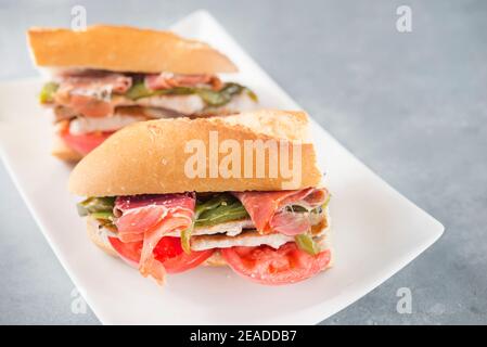 Sandwich Serranito tipico dell'Andalusia con prosciutto, pepe e lombo di maiale alla griglia Foto Stock