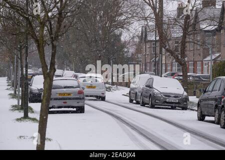 Merton, Londra, Regno Unito. 9 febbraio 2021. La nevicata mattutina più pesante nel sud di Londra crea condizioni di guida più scivolose su strade suburbane non trattate, ma le strade principali in erba rimangono chiare senza scappatoie per il traffico. Credit: Malcolm Park/Alamy Live News. Foto Stock