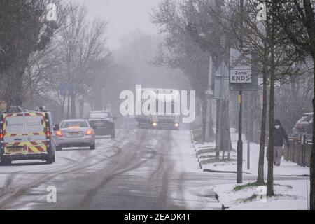 Merton, Londra, Regno Unito. 9 febbraio 2021. La nevicata mattutina più pesante nel sud di Londra crea condizioni di guida più scivolose su strade suburbane non trattate, ma le strade principali in erba rimangono chiare senza scappatoie per il traffico. Credit: Malcolm Park/Alamy Live News. Foto Stock