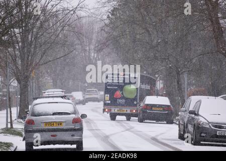 Merton, Londra, Regno Unito. 9 febbraio 2021. La nevicata mattutina più pesante nel sud di Londra si trova su strade suburbane non trattate, ma le strade principali in erba rimangono sgombrate senza scappatoie per il traffico. Un furgone Tesco per la consegna a casa al lavoro nella neve. Credit: Malcolm Park/Alamy Live News. Foto Stock