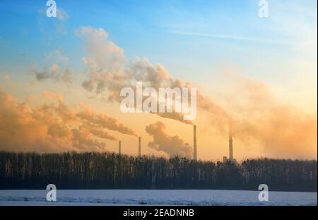 Il vapore dalla fabbrica dai camini all'alba in inverno sembra molto interessante Foto Stock