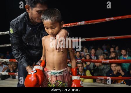 Allenatore cercare di incoraggiare Muay Thai Kid fighter durante la lotta. Foto Stock