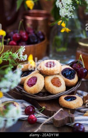 Biscotti di mandorle con marmellata su rustico sfondo di legno Foto Stock