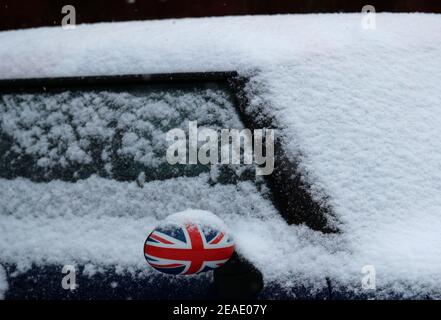 Coalville, Leicestershire, Regno Unito. 9 febbraio 2021. Meteo nel Regno Unito. Uno specchio alare Mini CooperÕs stampato con una bandiera Union si stacca dalla neve. Credit Darren Staples/Alamy Live News. Foto Stock
